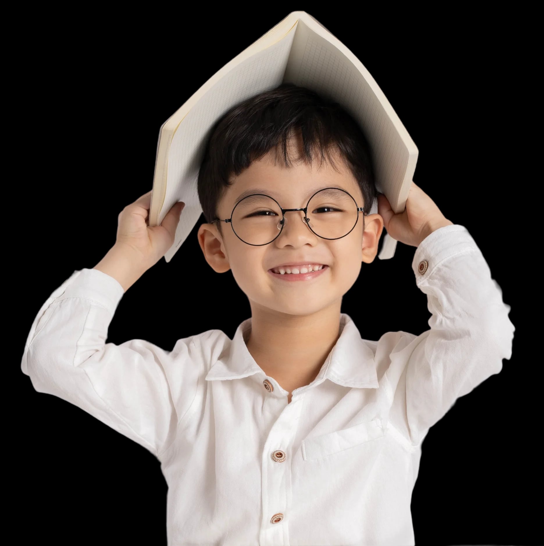 Boy smiling with book over his head